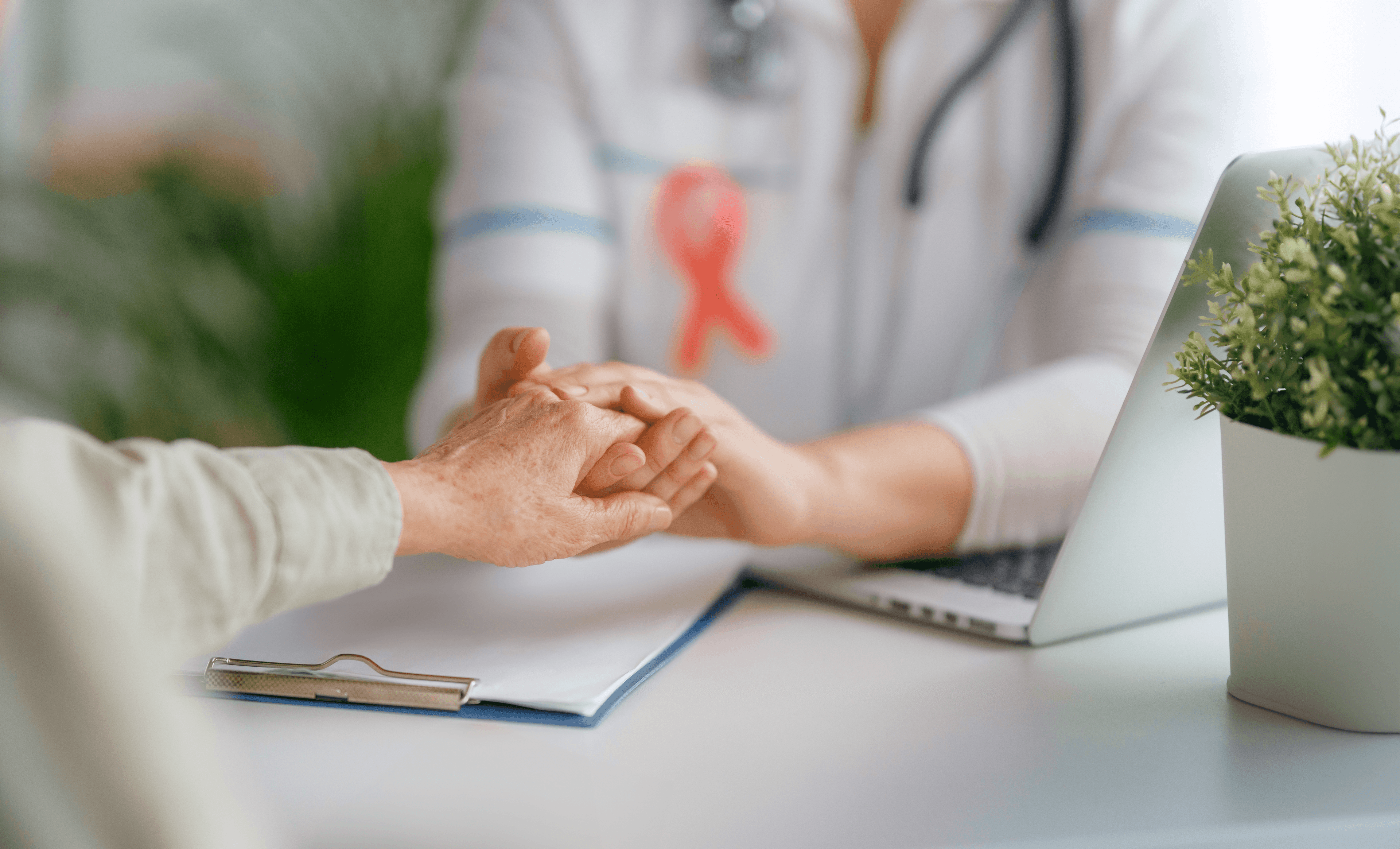 Splecione dłonie lekarki i pacjentki otrzymującej diagnozę nowotworu piersi raka potrójnie ujemnego 